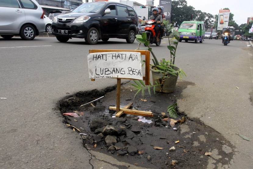Sejumlah kendaraan melintasi jalan yang rusak berlubang di Jalan KS Tubun, Kota Bogor, Jawa Barat, Senin (11/4). 
