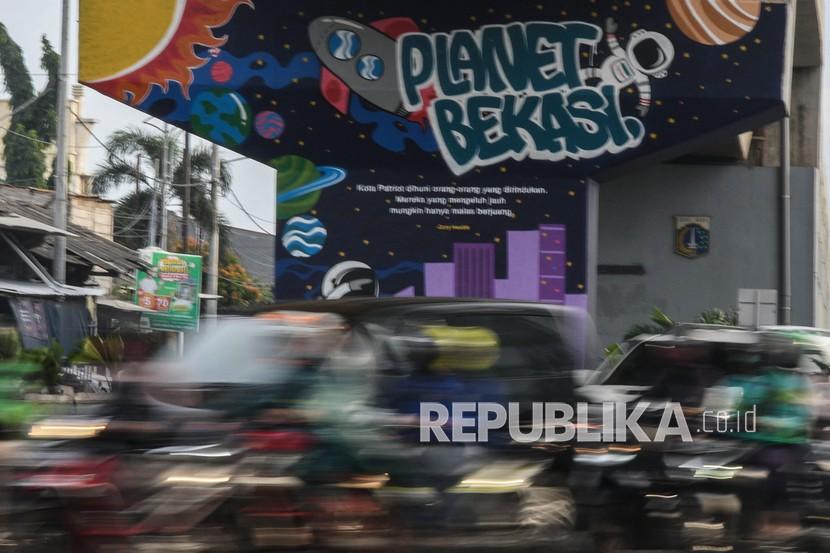 Sejumlah kendaraan melintasi mural Planet Bekasi, Jawa Barat. Pemerintah Kota Bekasi memperpanjang Pemberlakuan Pembatasan Kegiatan Masyarakat (PPKM) hingga 31 Mei untuk menurunkan kasus positif Covid-19. (ilustrasi)