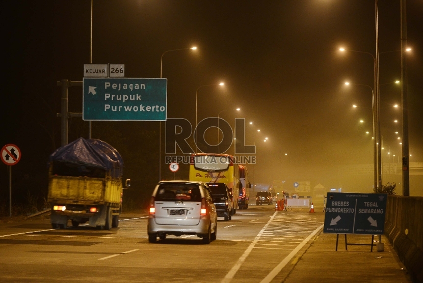 Sejumlah kendaraan memasuki exit jalan tol Pejagan setelah ruas jalan tol Pejagan-Pemalang ditutup, Jawa Barat, Ahad (12/7) malam.   (Republika/Raisan Al Farisi)