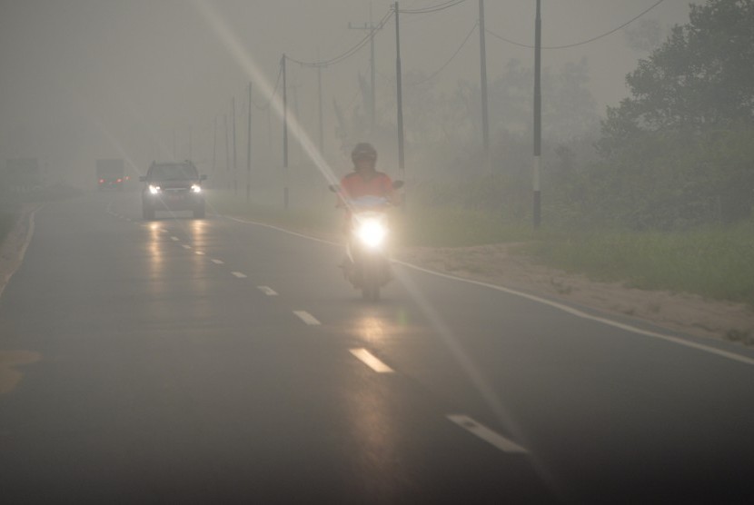 Sejumlah kendaraan menembus kabut asap yang menyelimuti Kota Palangka Raya, Kalteng, Selasa (27/10). 