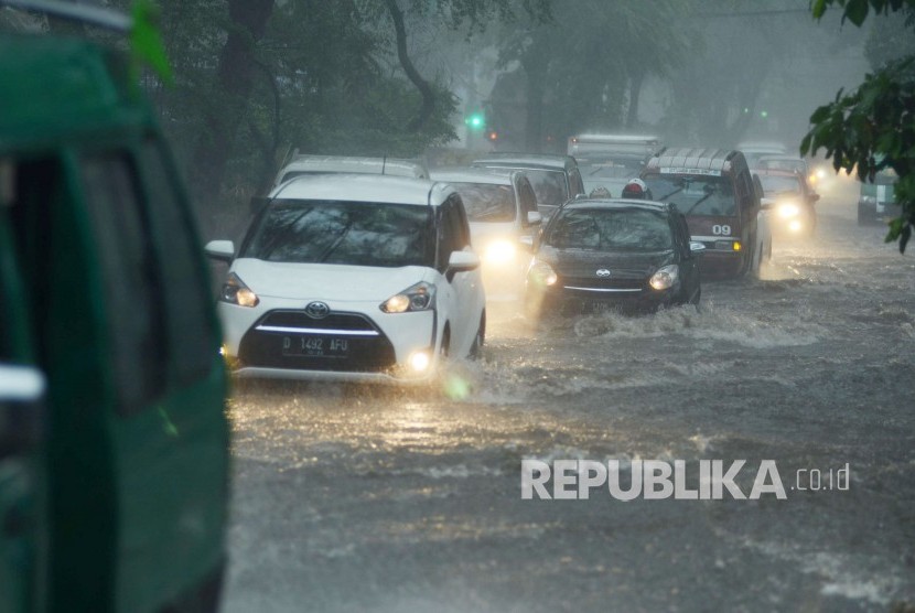 Sejumlah kendaraan menerobos banjir di Jalan Supratman, akibat meluapnya drainase saat hujan deras yang mengguyur Kota Bandung, Kamis (22/11).