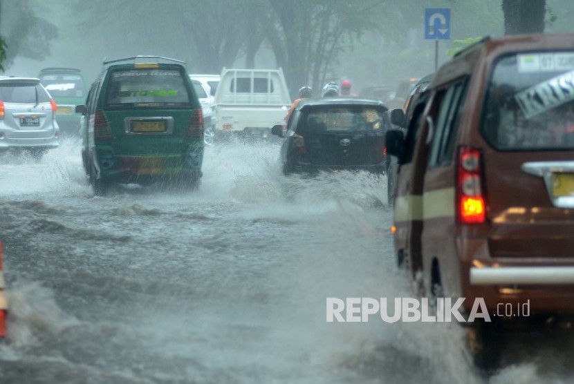 Sejumlah kendaraan menerobos banjir akibat luapan air drainase saat hujan deras yang mengguyur Kota Bandung, Kamis (22/11).