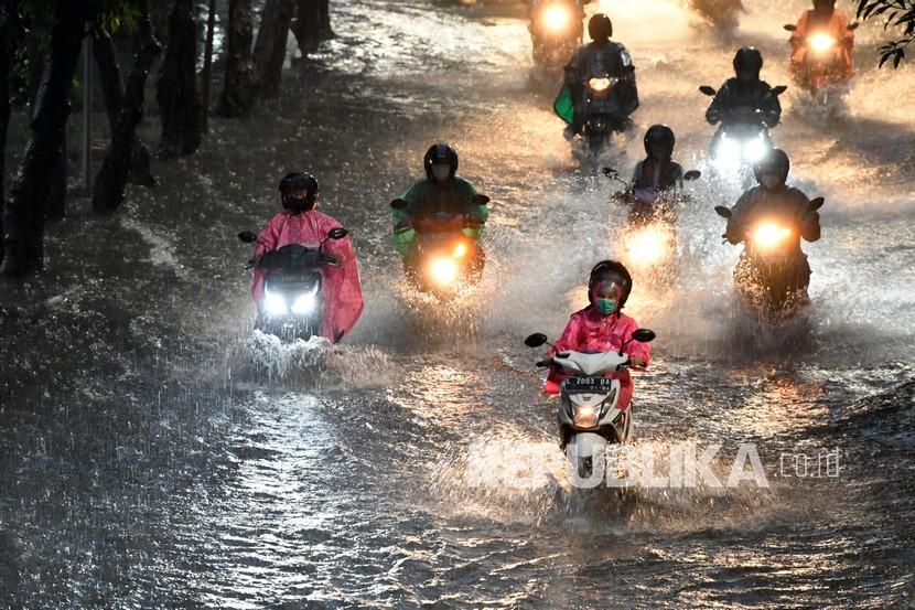 Sejumlah kendaraan menerobos genangan air di jalan raya di Surabaya, Jawa Timur, Kamis (30/12/2021). Sejumlah jalan di Surabaya tergenang air akibar hujan deras. BMKG Sebut Potensi Cuaca Ekstrem Terjadi pada 17-22 Januari 2022