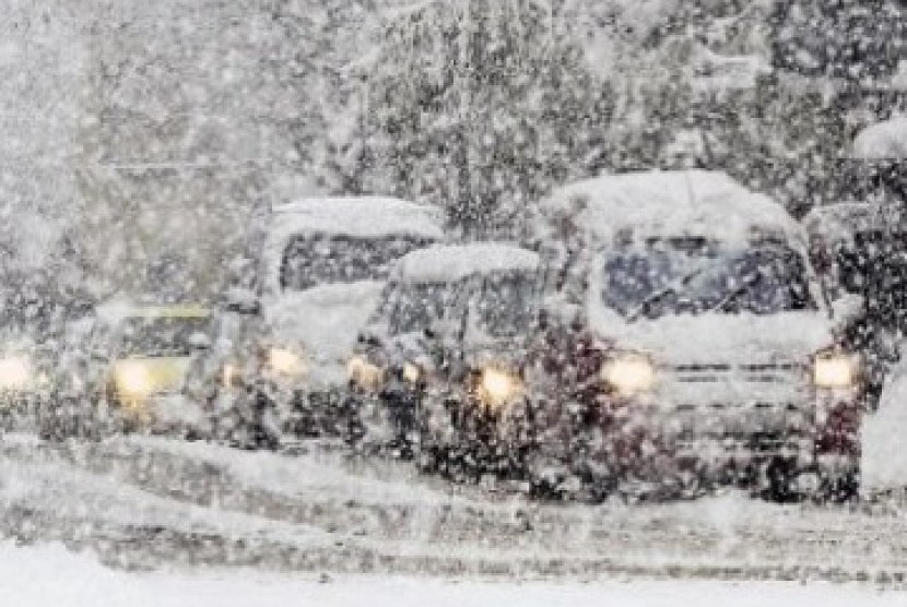 Sejumlah kendaraan merangkak di jalan menuju tertutup salju tebal menuju York, Inggris, hari ini (2/12)