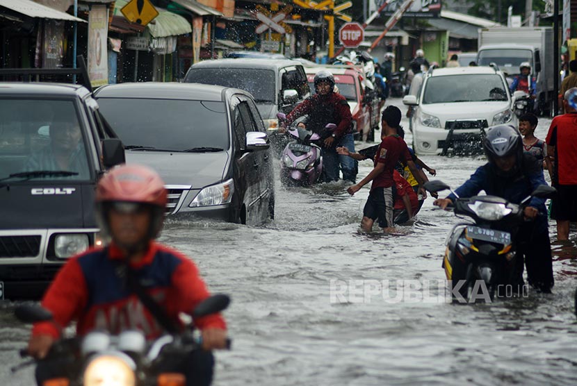 Sejumlah kendaraan mogok saat mencoba menerobos banjir di jalan raya Trosobo, Sidoarjo, Jawa Timur, Senin (10/10).