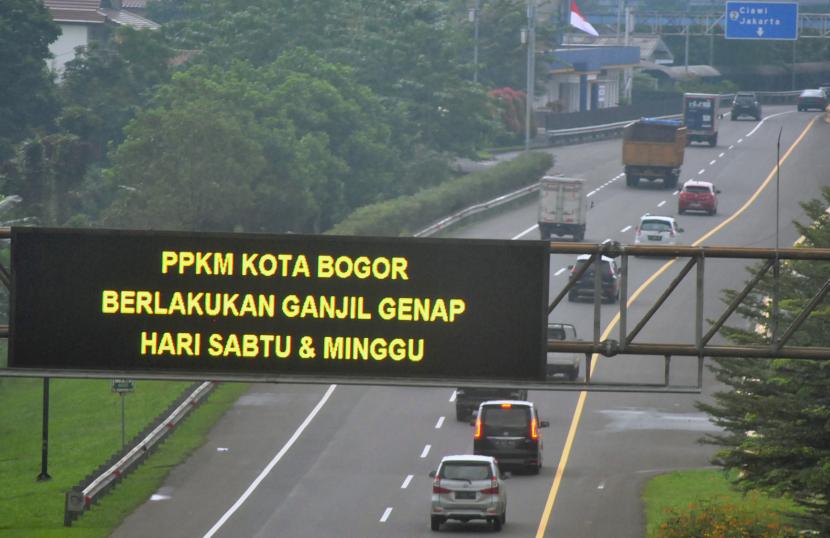 Sejumlah kendaraan roda empat melaju di bawah layar elektronik yang mengumumkan pemberlakuan ganjil-genap di tol Jagorawi, Kota Bogor, Jawa Barat.