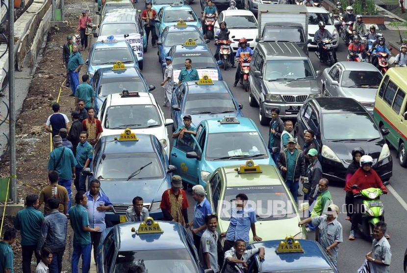 Sejumlah kendaraan taksi yang tergabung dalam Gabungan Pengemudi Taksi Bandung (GPTB) memadapati ruas jalan untuk melakukan unjuk rasa menuntut hentikan taksi ilegal di depan Kantor Balai Kota Bandung, Kota Bandung, Rabu (2/11). 