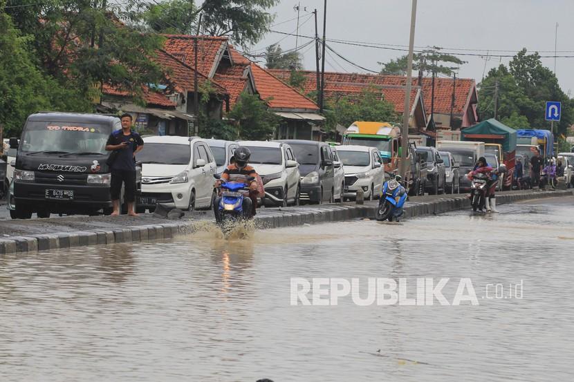 Sejumlah kendaraan terjebak kemacetan akibat banjir, di jalur Pantura Losarang, Indramayu, Jawa Barat, Senin (8/2/2021). Tingginya intensitas hujan dan luapan air sungai mengakibatkan jalur pantura Losarang terendam banjir dan membuat kemacetan sepanjang dua kilometer dari arah Jakarta maupun dari arah Jawa Tengah. 