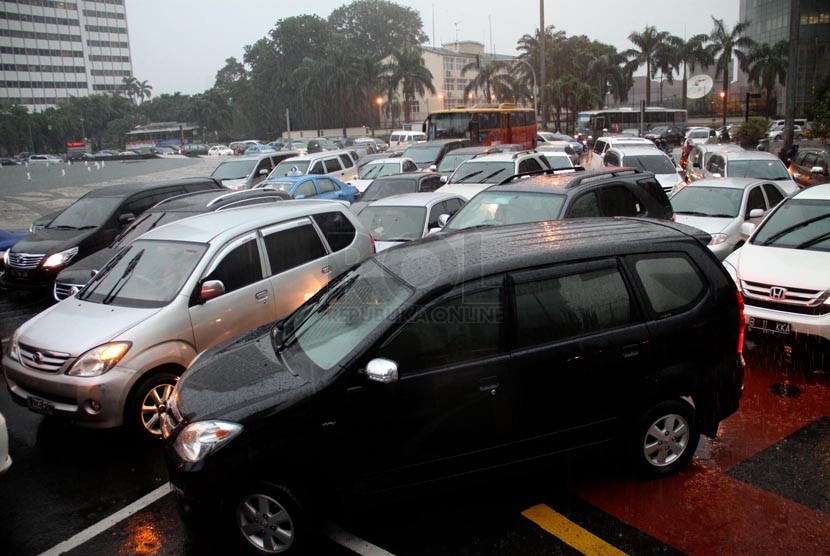   Sejumlah kendaraan terjebak kemacetan ketika hujan deras mengguyur kawasan Jalan Thamrin, Jakarta, Jumat (21/12).   (Republika/Yasin Habibi)