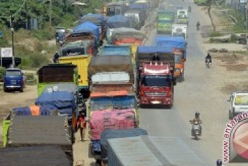 Sejumlah kendaraan truk berjalan merayap di ruas Jalan Ir Soekarno Hatta Kota Bandarlampung, Selasa (9/07). Jalan lintas Sumatera itu menjadi salah satu titik rawan macet saat arus mudik karena pengerjaan pelebaran badan jalan yang belum rampung sejak bebe