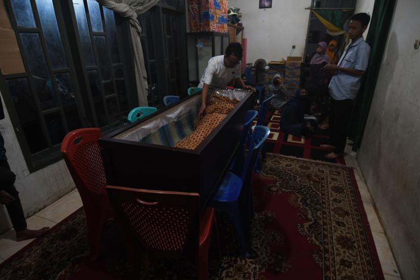 Sejumlah kerabat berada di dekat jenazah Mahmud Ismaun korban penembakan kelompok kriminal bersenjata (KKB) di rumah duka di Palu, Sulawesi Tengah, Ahad (17/7/2022). Jenazah Mahmud Ismaun yang merupakan salah satu dari delapan korban penembakan KKB di Papua tiba di Kota Palu dan akan dimakamkan dipemakaman keluarga pada Senin (18/7/2022). 