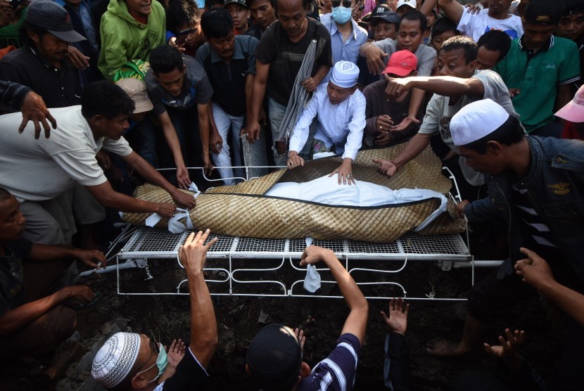 Sejumlah kerabat mengangkat jenazah terpidana mati kasus penyalahgunaan narkoba berkewarganegaraan Indonesia, Freddy Budiman ke liang lahat di Tempat Pemakaman Umum Mbah Ratu, Surabaya, Jawa Timur, Jumat (29/7).