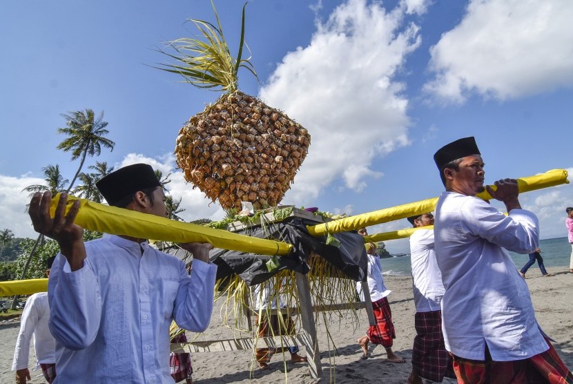 Sejumlah laki-laki mengangkat topat jelang acara Lebaran Topat, di Lombok, NTB.