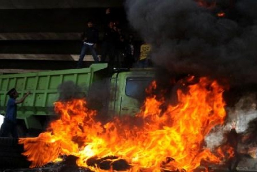 Sejumlah mahasiswa berada di atas truk dan membakar ban bekas saat berunjuk rasa menolak rencana kenaikan bahan bakar minyak (BBM) di Tol Reformasi, Makassar, Sulsel, Senin (29/4).