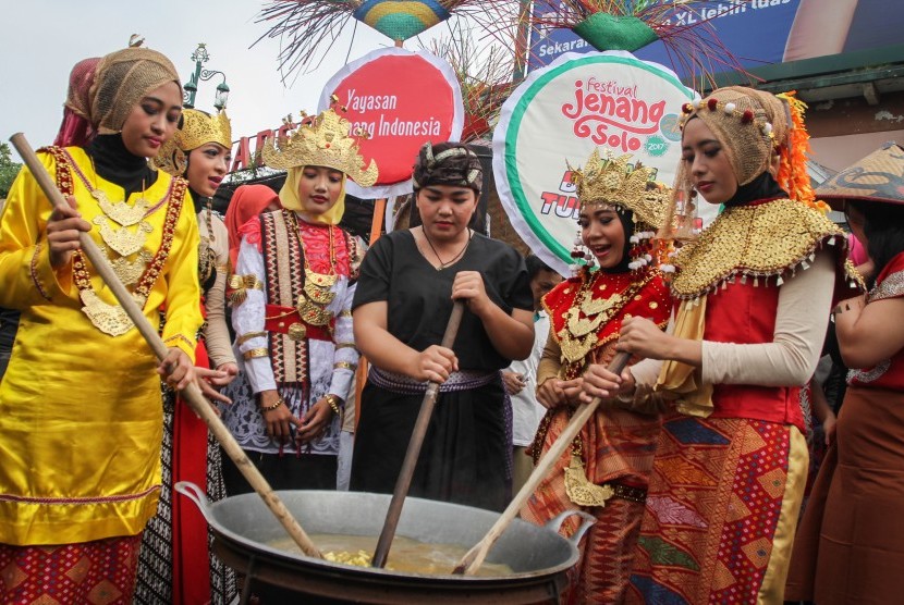 Sejumlah mahasiswa berpakaian adat membuat jenang Bhinneka Tunggal Ika dalam rangkaian acara Festival Jenang Nusantara 2017 di Ngarsopuro, Solo, Jawa Tengah, Ahad (12/2).