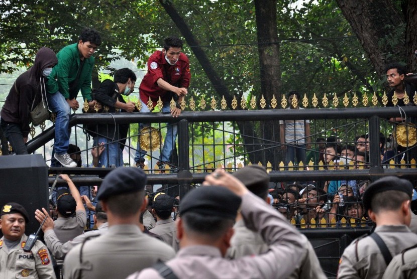 Sejumlah mahasiswa dari berbagai perguruan tinggi di Kota Medan menaiki pagar gedung saat melakukan aksi unjuk rasa di depan DPRD Sumut di Medan, Sumatra Utara, Selasa (24/9/2019). Aksi mahasiswa tersebut untuk menyampaikan aspirasi menolak revisi UU KPK dan RUU KUHP. 