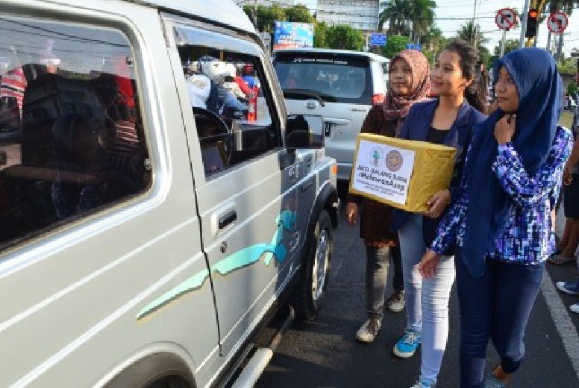 Sejumlah mahasiswa melakukan penggalangan dana peduli korban kabut asap di ruas Jalan Sudirman, Denpasar, Bali, Ahad (18/10).