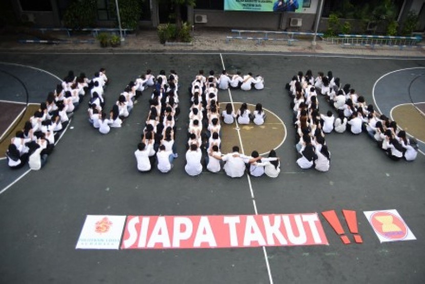 Sejumlah mahasiswa membentuk formasi tulisan MEA (Masyarakat Ekonomi Asean) di Lapangan Politeknik Universitas Surabaya (Ubaya), Surabaya, Jawa Timur, Jumat (18/12).