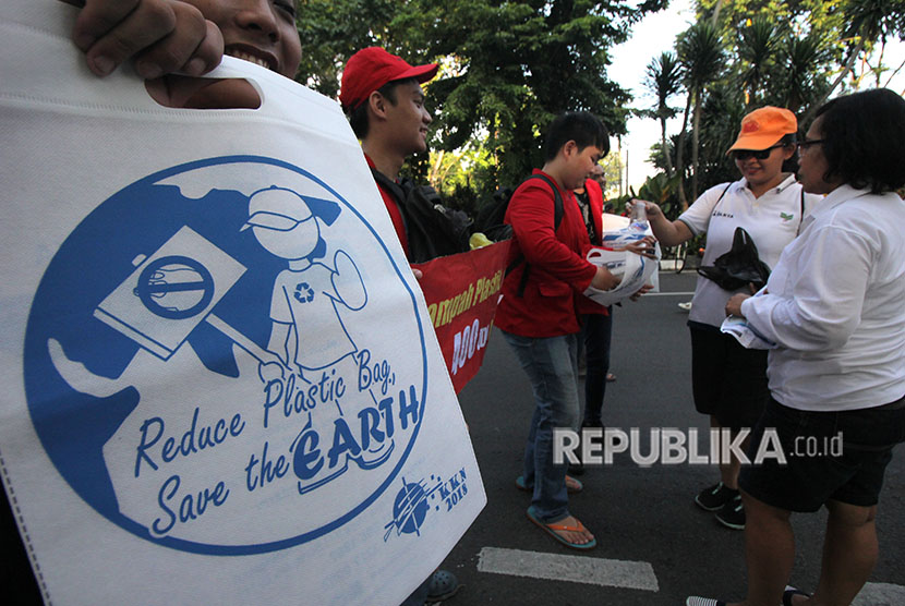 Sejumlah mahasiswa menukar kantong plastik milik warga dengan kantong kain di Surabaya.