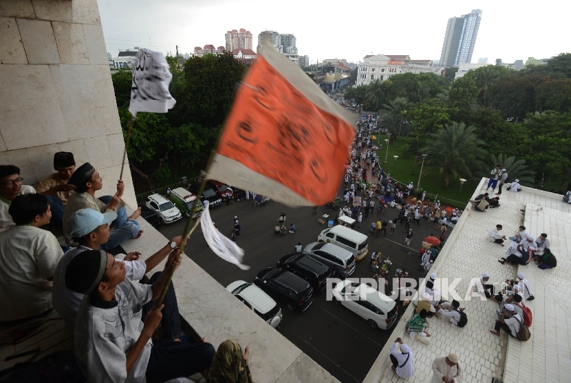 Sejumlah massa aksi 313 mengibarkan bendera sebelum melaksanakan Shalat Jumat bersama di Masjid Istiqlal, Jakarta, Jumat (31/3)