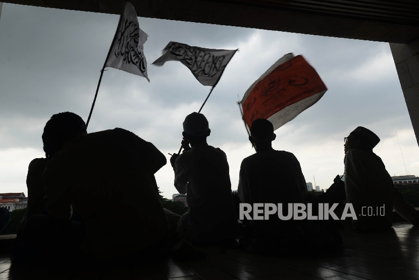 Sejumlah massa aksi 313 mengibarkan bendera sebelum melaksanakan Shalat Jumat bersama di Masjid Istiqlal, Jakarta, Jumat (31/3)