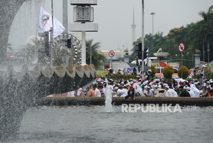 Sejumlah massa berdoa bersama sebelum melaksanakan Shalat Jumat saat aksi di Bundaran Patung Kuda, Jakarta, Jumat (4/11). (Republika/Raisan Al Farisi)