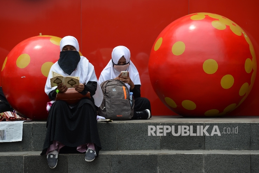 Sejumlah massa membaca ayat suci Al Quran sebelum melaksanakan Shalat Jumat saat aksi di Bundaran Patung Kuda, Jakarta, Jumat (4/11)