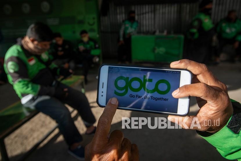 Sejumlah mitra layanan ojek daring Gojek menunjukkan logo merger perusahaan Gojek dan Tokopedia yang beredar di media sosial di Jakarta, Jumat (28/5/2021). 
