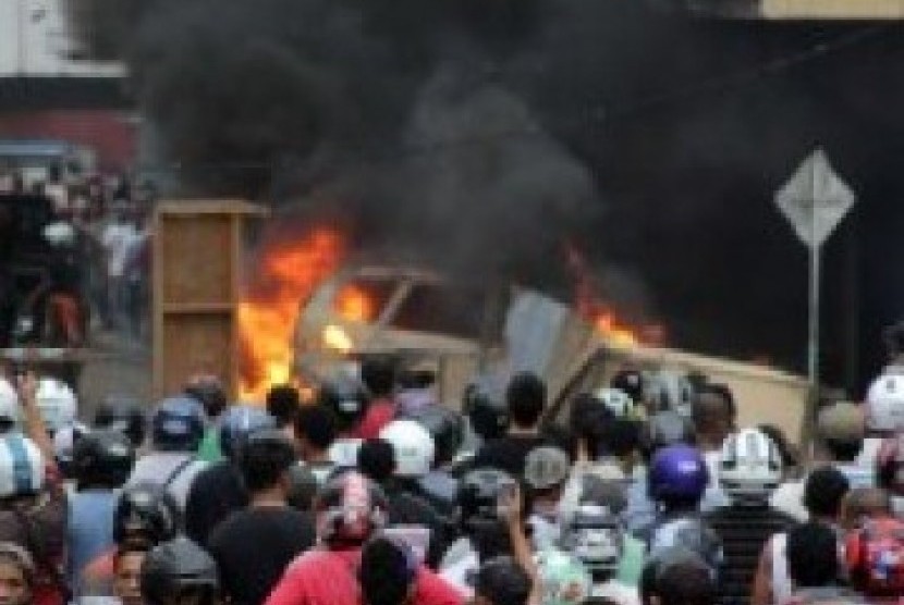Sejumlah mobil dibakar massa saat kericuhan yang terjadi di Kota Ambon, Minggu (11/9). Kericuhan antarwarga di Ambon diwarnai dengan saling lempar batu, memblokir jalan dan merusak/membakar kendaraan. Kericuhan tersebut terjadi akibat warga terprovokasi me