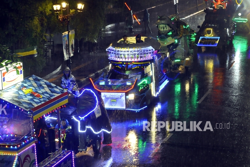   Sejumlah mobil hias melintas saat parade light festival bertemakan Robot Galactica di Jalan Merdeka , Kota Bandung, Ahad (9/10) malam.