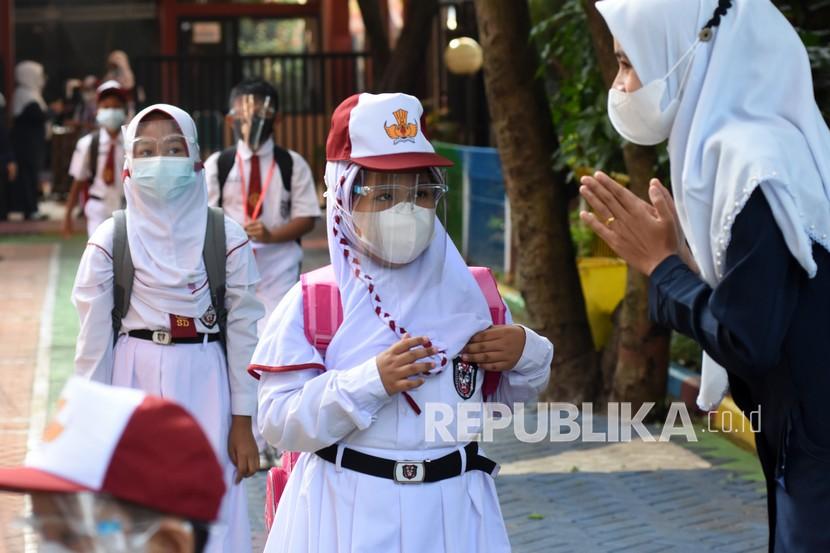 Sejumlah murid antre menjaga jarak memasuki ruang kelasnya saat mengikuti kegiatan pembelajaran tatap muka (PTM) terbatas di SDN Lenteng Agung 07, Jakarta Selatan.