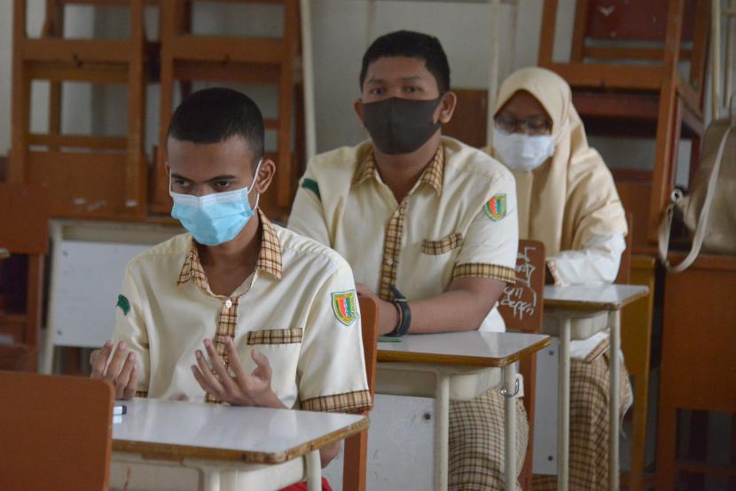 Sejumlah murid berdoa sebelum mengikuti Ujian Akhir Sekolah (UAS) di Sekolah Menengah Umum Negeri-2 Banda Aceh, Kamis (1/4/2021). Ujian Akhir Sekolah (UAS) hingga tanggal 8 April 2021 di daerah itu berlangsung serentak dengan pembatasan jumlah murid dan menerapan protokol kesehatan guna mencegah penyebaran COVID-19.