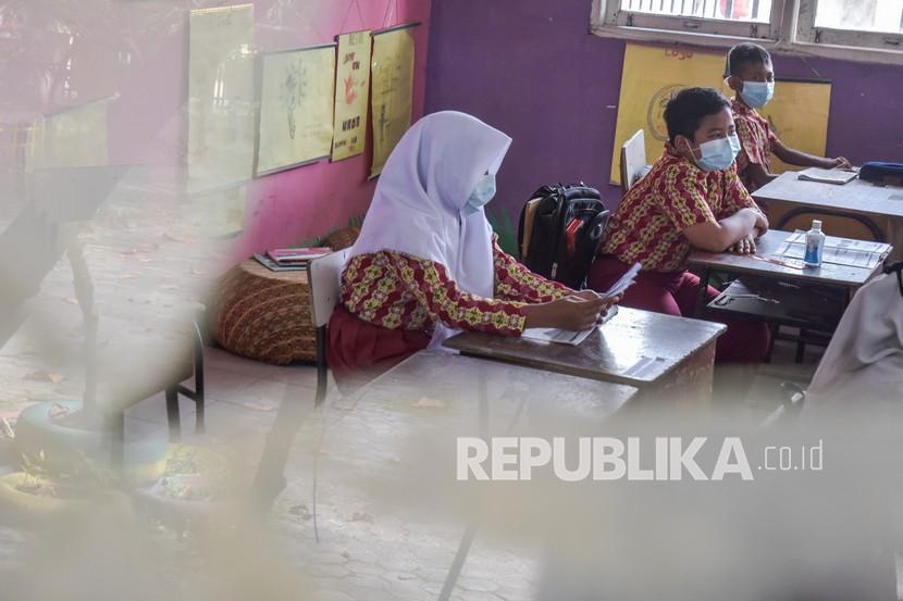 Sejumlah murid kelas 6 mengenakan masker ketika kembali belajar tatap muka di SDN 159, Kota Pekanbaru, Riau, Kamis (11/2/2021). Dinas Pendidikan Kota Pekanbaru telah menutup aktivitas belajar mengajar 11 SMP seiring meningkatnya kasus konfirmasi Covid-19 di ibu kota Provinsi Riau ini.