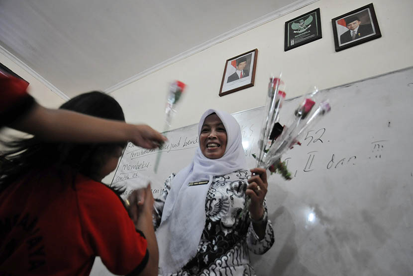 Sejumlah murid memberikan bunga untuk guru mereka di SDN Mekarjaya 11, Depok, Jawa Barat, Rabu (25/11).  (Antara/Indrianto Eko Suwarso)