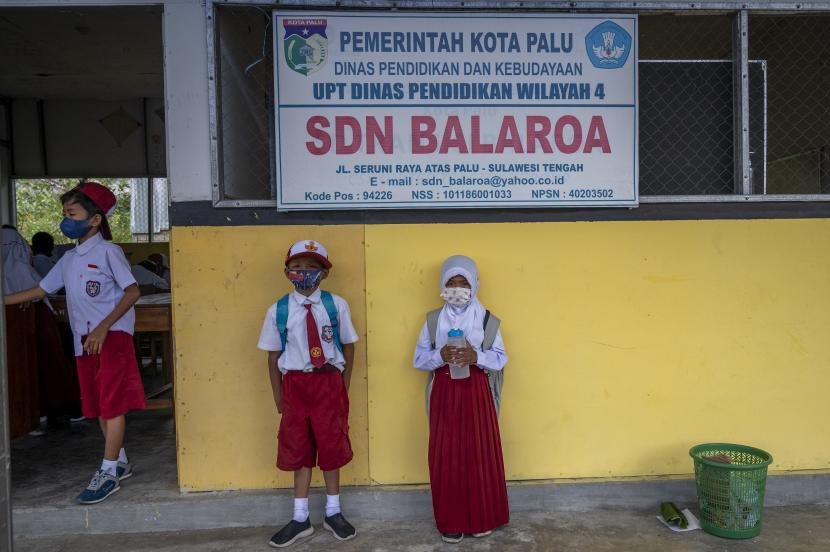 Sejumlah murid penyintas bencana likuifaksi bersiap mengikuti Pembelajaran Tatap Muka (PTM) perdana di sekolah darurat bencana SDN Balaroa, Palu, Sulawesi Tengah, Senin (18/10). Setelah belajar secara daring akibat pandemi COVID-19 selama hampir dua tahun, sekolah darurat yang berada di kawasan Hunian Tetap (Huntap) Balaroa itu kembali melakukan kegiatan belajar secara langsung dengan menerapkan protokol kesehatan yang ketat.