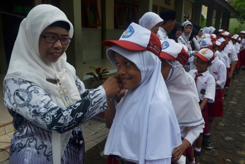 Sejumlah murid Sekolah Dasar(SD) berjajar antre untuk bersalaman kepada gurunya sambil mengucapkan Selamat Hari Guru. (Ilustrasi)