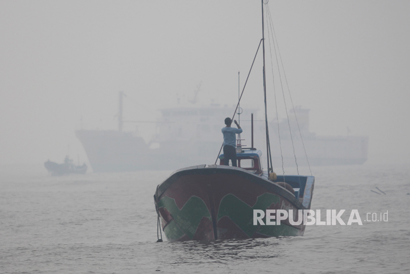Sejumlah nelayan beraktivitas di atas kapal di kawasan perairan Pelabuhan Jetty Meulaboh, Aceh Barat, Aceh, Kamis (27/7).Kabut asap akibat kebakaran lahan gambut di sejumlah wilayah di Aceh Barat menyebabkan terganggunya aktivitas nelayan di perairan karena faktor jarak pandang yang hanya berkisar 15 sampai 30 meter  
