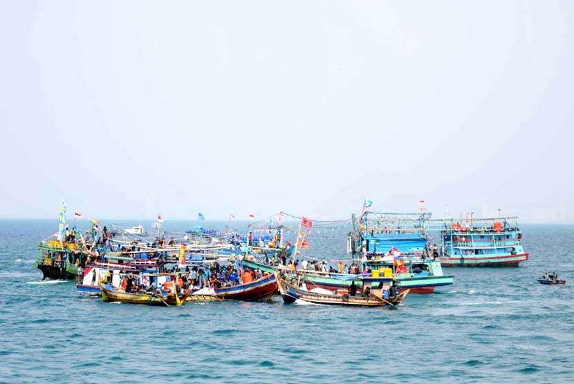 Sejumlah nelayan bersama keluarga menaiki kapal mengikuti prosesi Nadran Nelayan di lepas pantai Muara Karang, Jakarta, Selasa (10/6). Nadran merupakan upacara adat para nelayan di pesisir pantai utara Jawa, seperti Subang, Indramayu dan Cirebon yang bertu