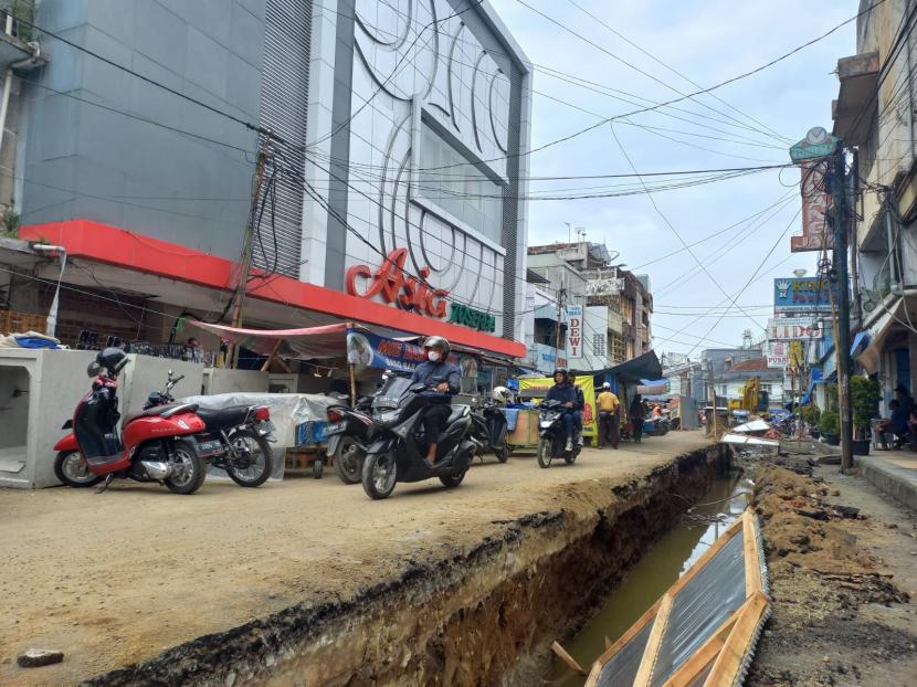 Sejumlah orang beraktivitas di Jalan Cihideung, Kota Tasikmalaya, Senin (25/7/2022). Pemkot Tasikmalaya saat ini sedang mengerjakan proyek penataan trotoar di Jalan Cihideung dan Jalan KH Z Mustofa. 