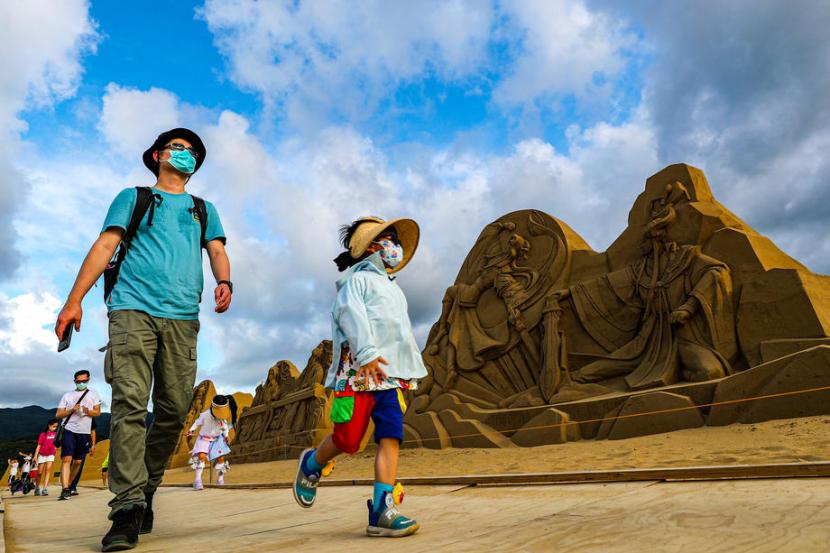 Sejumlah orang berjalan di salah satu destinasi wisata di Taiwan, Pantai Fulong yang berlokasi di New Taipei City, beberapa waktu lalu. Di lokasi tersebut sedang diadakan festival kreasi pasir yang akan diselenggarakan hingga 10 Oktober 2022.