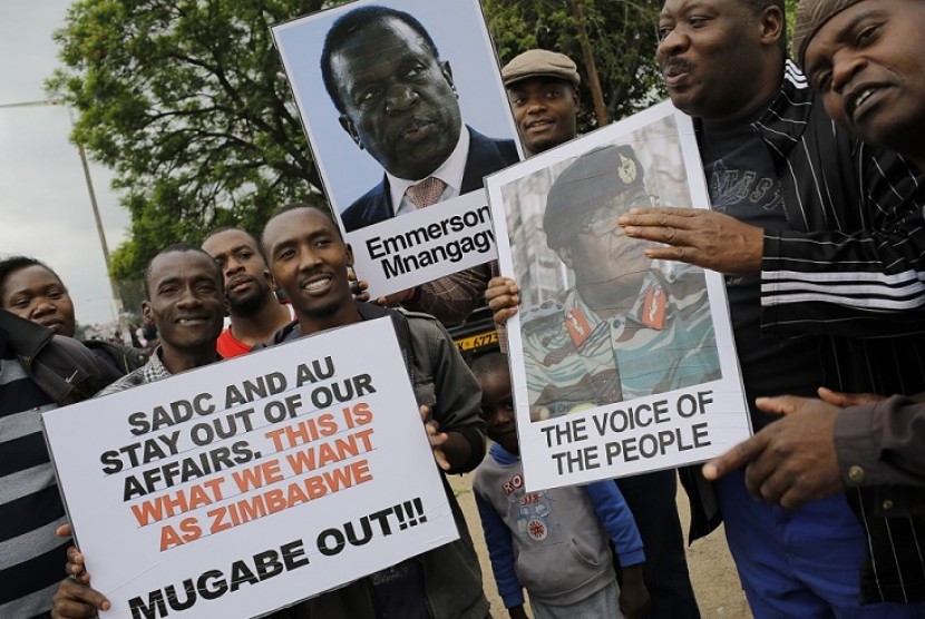 Sejumlah orang membawa poster yang berisikan tuntutan agar Presiden Zimbabwe Robert Mugabe mundur, di Harare, Zimbabwe, Sabtu (18/11).