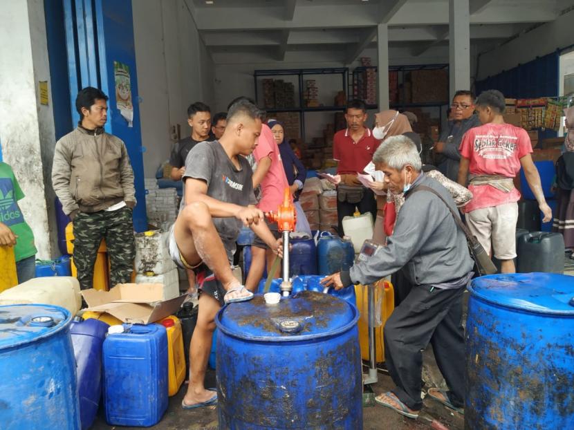 Sejumlah orang mengantre di salah satu agen minyak goreng curah di Pasar Cikurubuk, Kota Tasikmalaya, Senin (21/3/2022). Di agen itu, minyak goreng curah dijual dengan harga Rp 18.500 per kilogram.