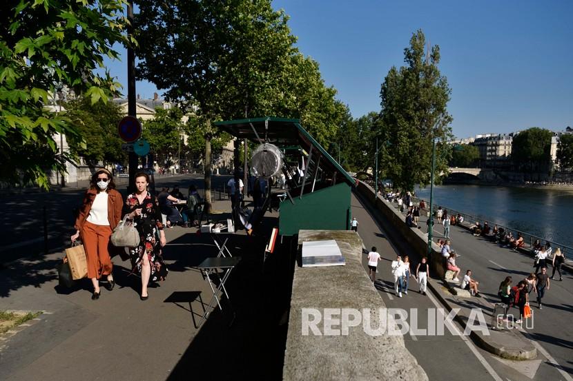 Sejumlah orang menikmati sinar matahari di sepanjang tepi sungai Seine pada akhir pekan. Bisnis penjualan buku di tepi Sungai Seine telah dimulai sejak abad ke-16. Ilustrasi.