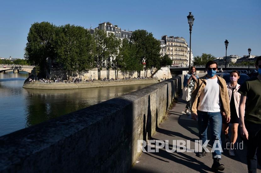 Sejumlah orang menikmati sinar matahari di sepanjang tepi sungai Seine pada akhir pekan pertama setelah dua bulan diberlakukannya lockdown di Paris, Prancis,Ahad (17/5). Prancis mulai melongarkan lockdown secara bertahap di tengah pandemi COVID-19. 