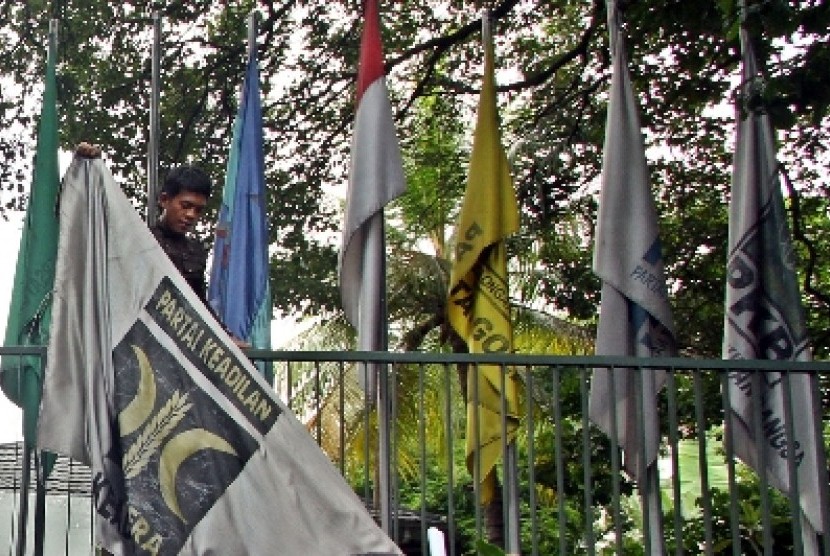 Sejumlah orang menurunkan bendera PKS yang terpasang di kantor Sekretariat Gabungan (Setgab), Jakarta, Rabu (4/4). 
