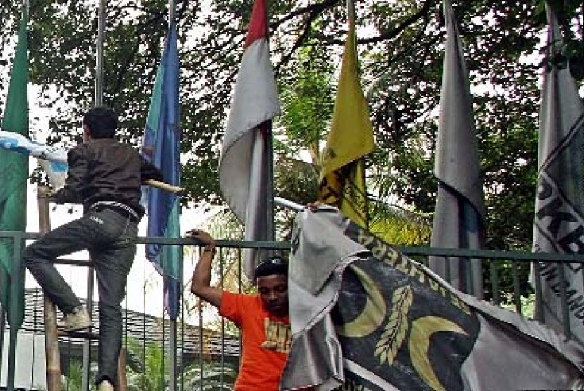 Sejumlah orang menurunkan bendera PKS yang terpasang di kantor Sekretariat Gabungan (Setgab).
