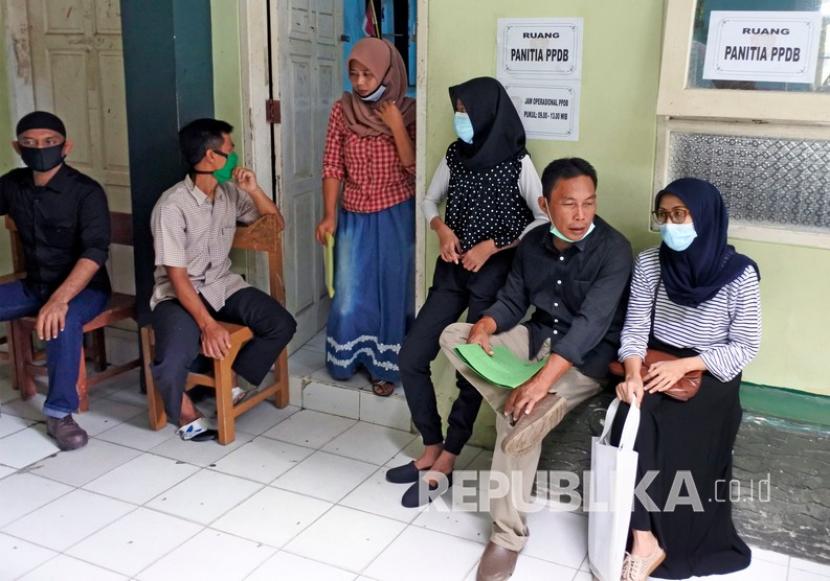 Sejumlah orang tua calon siswa antre untuk wawancara dan verifikasi pemeriksaan berkas PPDB (Penerimaan Peserta Didik Baru) di SMP Negeri 2 Serang, Banten, Senin (22/6/2020). Proses penerimaan peserta didik baru dilakukan secara serentak di Banten sejak tanggal 17 - 24 Juni 2020. 