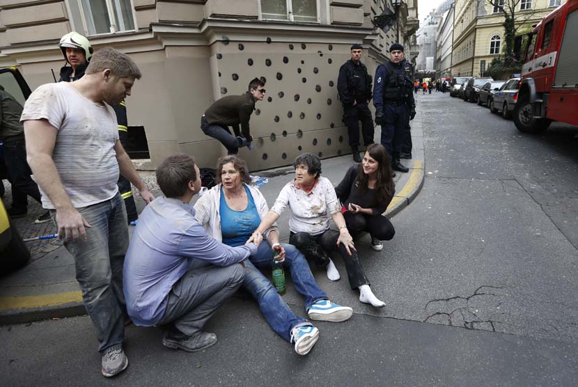  Sejumlah orang yang terluka duduk di trotoar setelah ledakan yang terjadi di pusat kota Praha, Republik Ceko, Senin (29/4).    (AP/Petr David Josek)