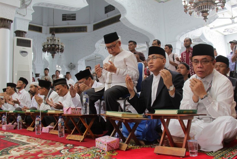 Sejumlah pasangan cagub-cawagub Aceh berdoa seusai mengikuti uji baca Alquran di Masjid Raya Baiturrahman, Banda Aceh. 