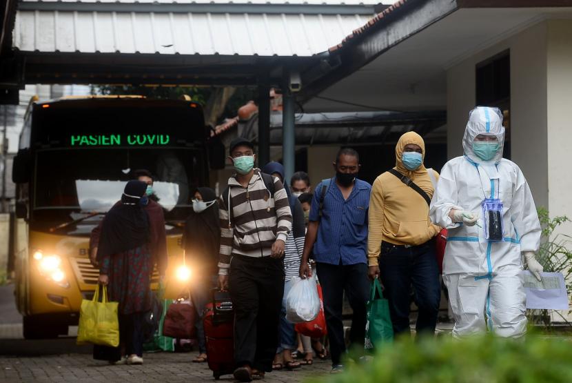 Sejumlah pasien positif Covid-19 saat tiba untuk melakukan isolasi mandiri di Graha Wisata Ragunan, Jakarta, Selasa (22/12).